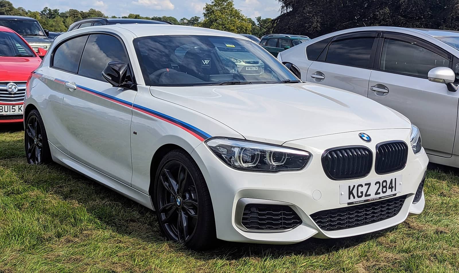 White BMW M140i Championship Edition with M stripes, front view