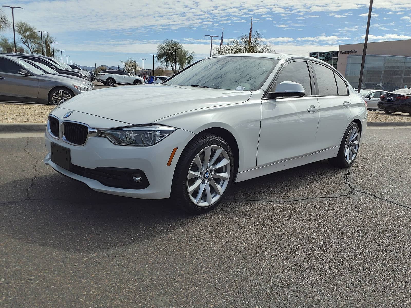 White BMW 320i sedan in base trim, front three-quarter view