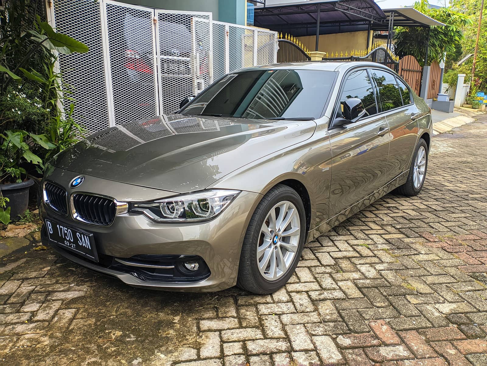 Bronze BMW 320i sedan, front three-quarter view