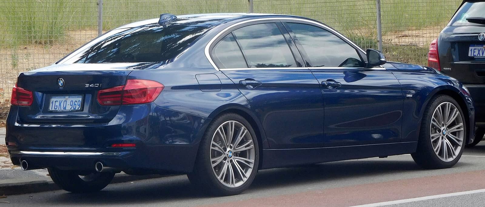 Blue BMW 340i Luxury Line sedan, rear three-quarter view