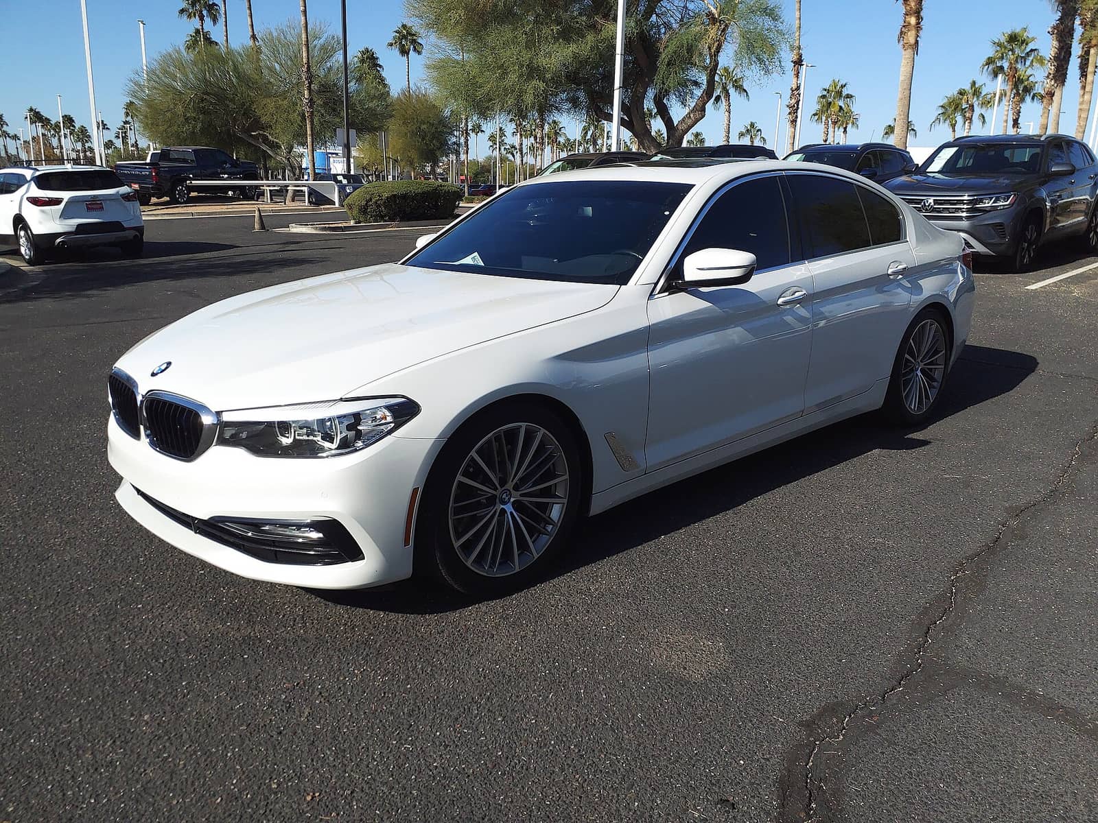 White BMW 530i in base trim, front three-quarter view