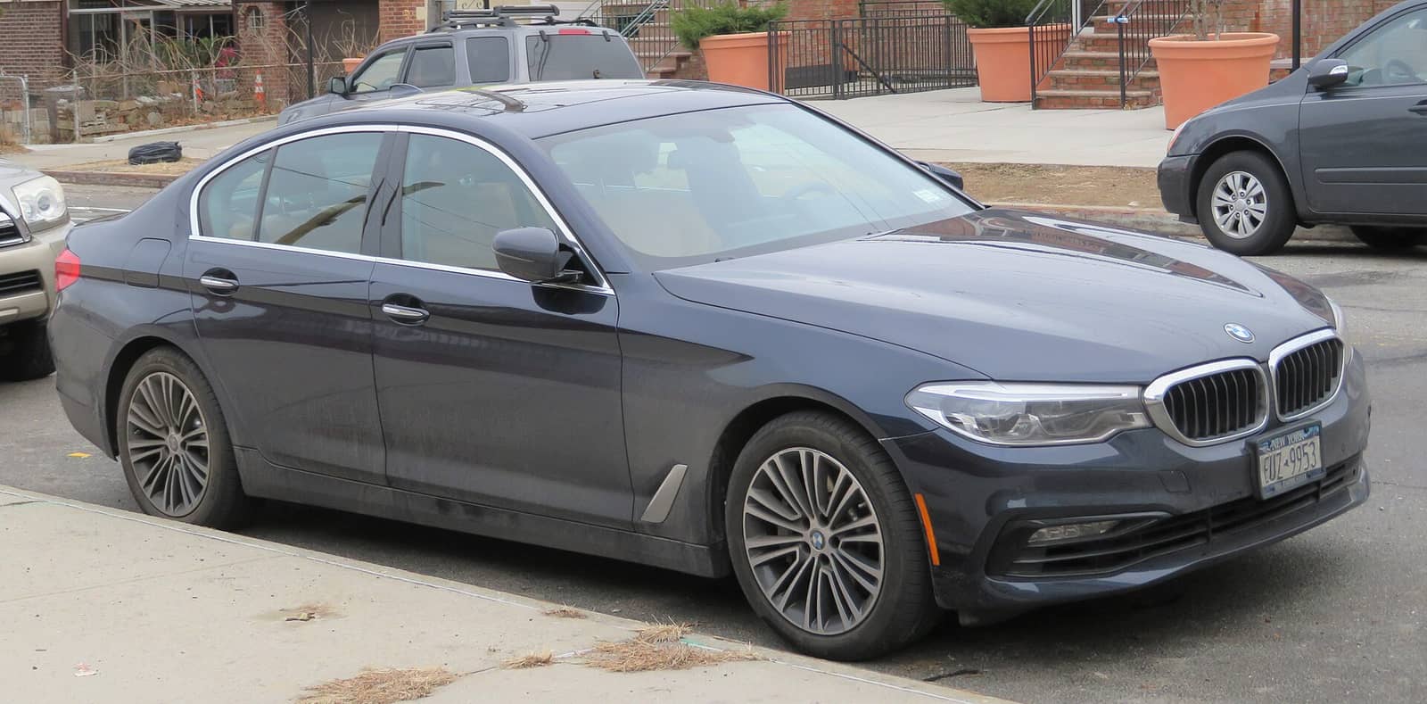 Grey BMW 5 Series sedan with standard styling, front three-quarter view