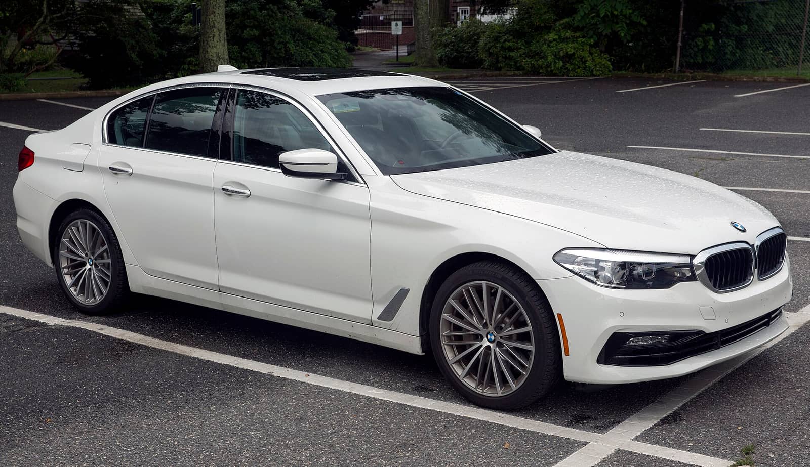 White BMW 5 Series sedan with standard styling, front three-quarter view