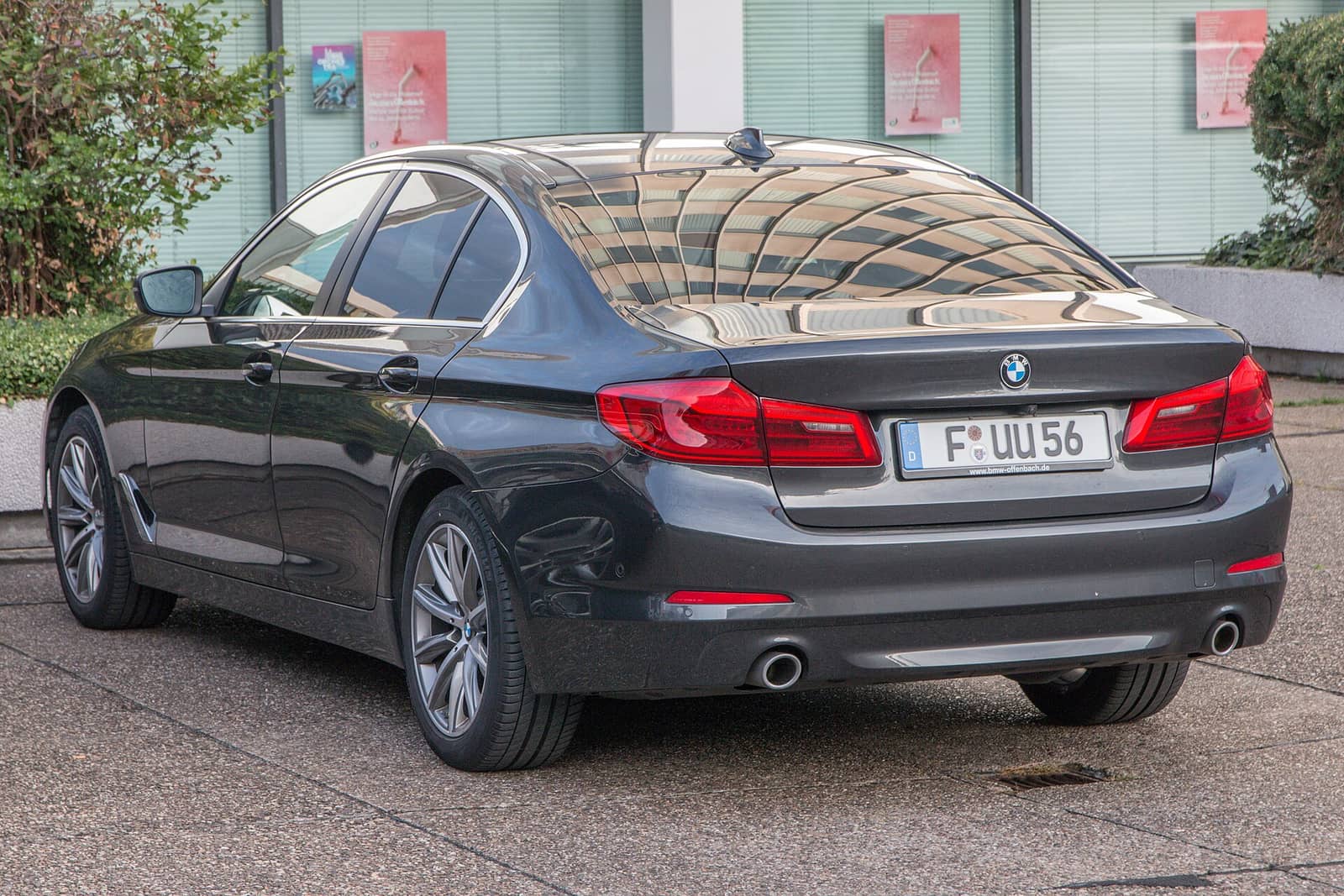 Dark grey BMW 5 Series sedan, rear three-quarter view