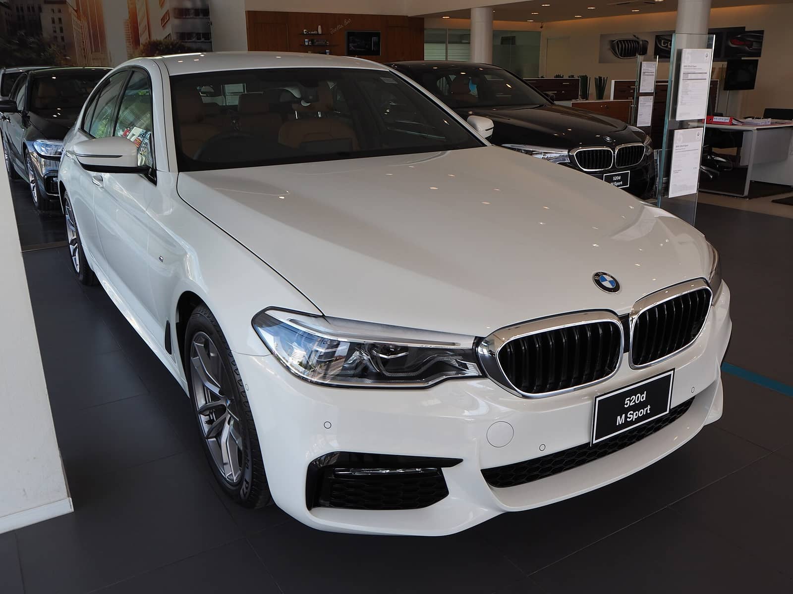 White BMW 5 Series with M Sport package, front three-quarter view