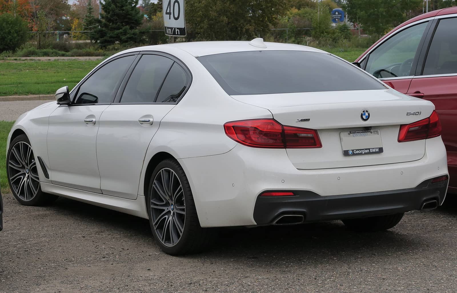 White BMW 540i xDrive with M Sport package, rear three-quarter view